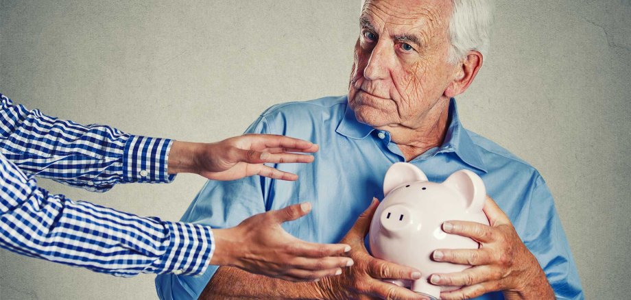 Closeup,Portrait,Senior,Man,Grandfather,Holding,Piggy,Bank,Looking,Suspicious