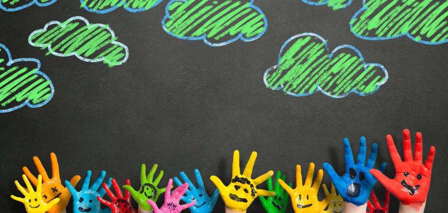 Colorful,Hands,In,Front,Of,A,Chalkboard,With,Clouds