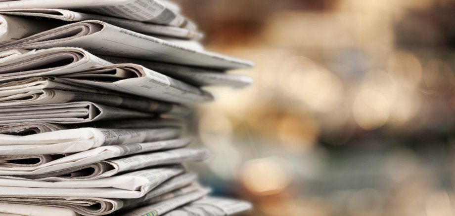 Pile,Of,Newspapers,Stacks,On,Blur,Background